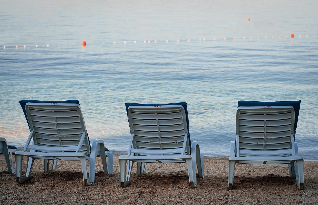 Croatia summer beach with blue water and coastal town buildings